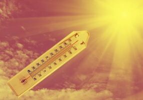 thermometer on wood plate sunshine background